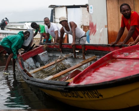 Fishers in Port Royal move a boat to higher ground in preparation for the storm