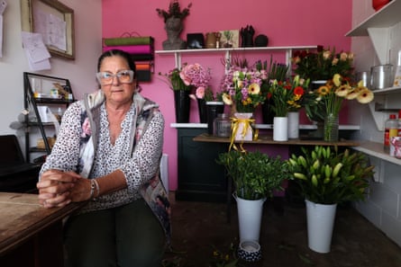Florist Kerry McCullough sits at the counter of her shop surrounded by colourful bouquets