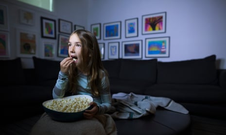 Girl watching TV with popcorn