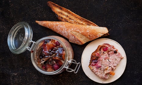 A slice of terrine of pork and smoked bacon next to a pot of cranberries and some toasted bread