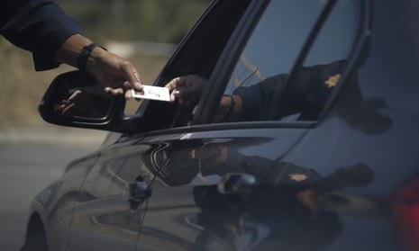 A police officer handing a license back to  car driver