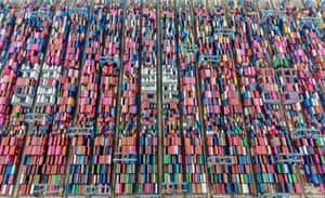 An aerial shot of hundreds of brightly coloured containers laid out in neat lines