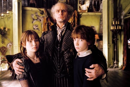 Dressed in character, Carrey stands between them and puts his arms around the children