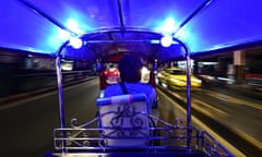 A tuk tuk driving in traffic in Bangkok