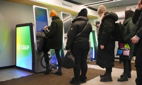 People stand in line to withdraw money from a cash machine in St Petersburg, Russia