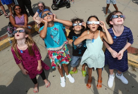 Spectators look skyward during a partial eclipse of the sun at the Cradle of Aviation Museum in Garden City, New York.