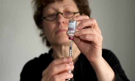 Woman drawing up insulin injection from a vial