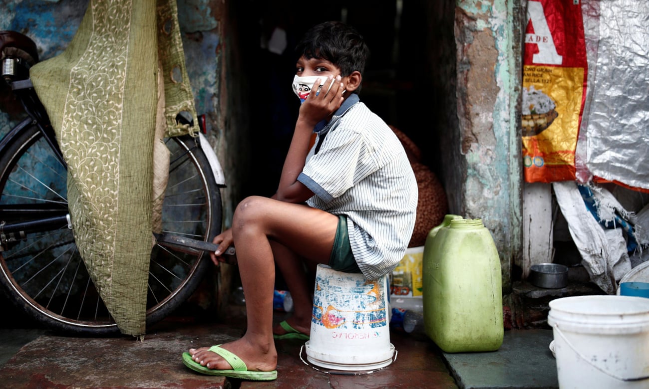 A boy wears a face mask in a slum area of Delhi, India