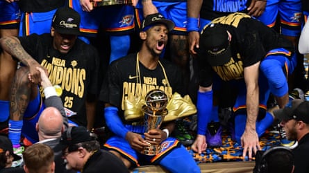 Shai Gilgeous-Alexander holds the Bill Russell NBA finals MVP trophy.