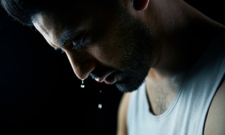 A man in a vest with sweat droplets pouring off his face