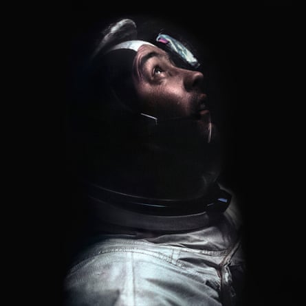 Apollo 9, 7 March 1969, astronaut James McDivitt against black background looking up out of his helmet as he docks the lunar module