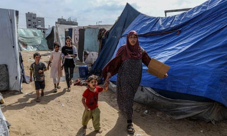 Palestinians who fled Israeli attacks trying to survive in the harsh conditions in Rafah.