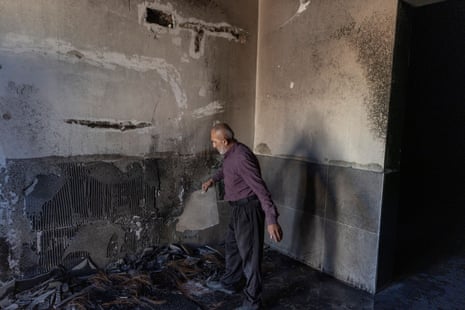 A man inspects the smoke-damaged walls inside a mosque.
