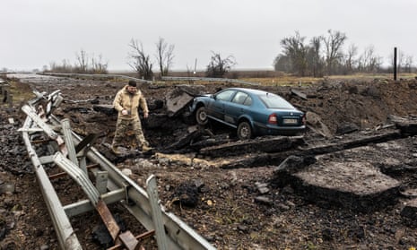 A man amid dirt and debris after the main road in Kherson city was bombed on Thursday night