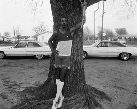Young black man dressed in sports gear in front of a tree in the deep south circa mid-1980s