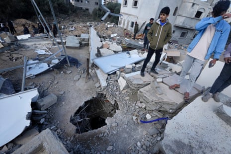 Palestinians look at the building of the Darwesh family, killed in the Israeli bombardment of the Gaza Strip, in Nuseirat refugee camp, central Gaza.