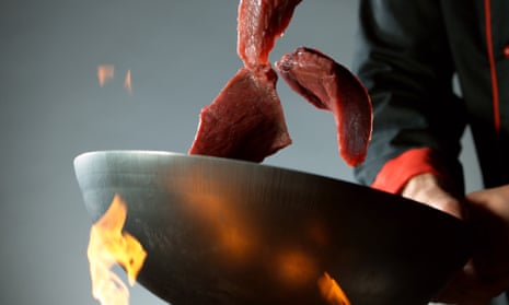 Thinly sliced steak being cooked in a hot wok.