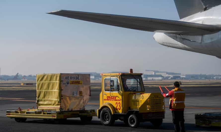 Workers unload containers carrying Mexico’s second shipment of the Pfizer/BioNTech Covid-19 vaccine from a plane at Benito Juarez international airport in Mexico City