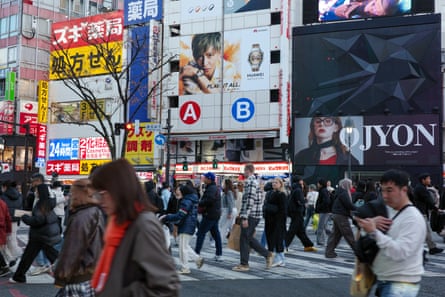 People cross an intersection in Shibuya district, Tokyo.