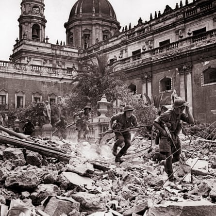Contemporary wartime photograph of troops running through the courtyard of an old building filled with rubble