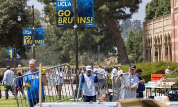 Workers move metal barriers at the site of a pro-Palestinian protest encampment after it was broken up by police officers at UCLA.