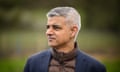 Sadiq Khan photographed outdoors with a blurred background of grass and trees; he is wearing a brown quilted anorak zipped up high under a dark blue jacket