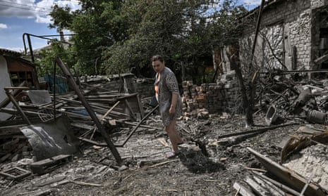 A woman stands in the yard of her destroyed house in the city of Lysychansk.