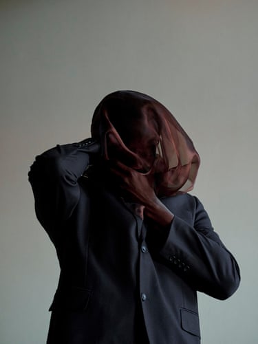 Self-portrait in a black suit and brown silky fabric, Black Belt, 2025 With the face veiled and the handdrawn towards the mouth, thefigure appears caught in the act ofsilencing itself. The suit becomesless a marker of identity than astructure worn on the body,revealing how patriarchalmasculinity can be sustainedthrough restraint, self-surveillanceand the fear of what mightescape.