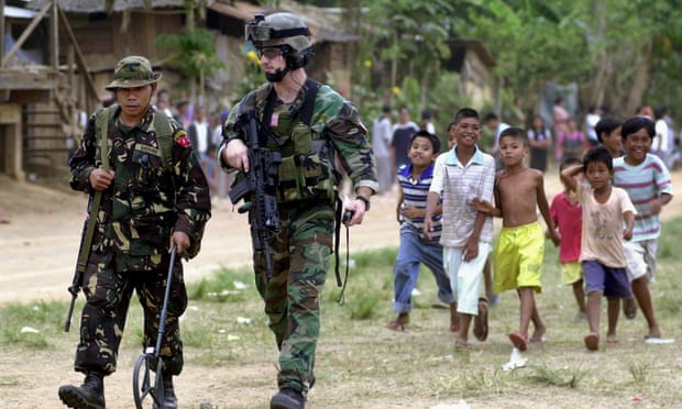 A US special forces member walks with a Filipino soldier in the southern Philippines in 2002.