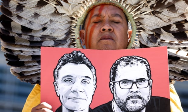 A Member of The Articulation of Indigenous Peoples of Brazil (APIB) holds the image of Dom Phillips and Bruno Pereira during a protest in Brussel on 16 June.