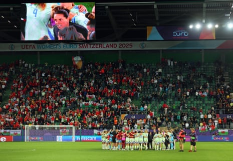 Wales players and unit huddle aft nan lucifer arsenic head Rhian Wilkinson is seen connected nan large surface giving a squad talk to them.