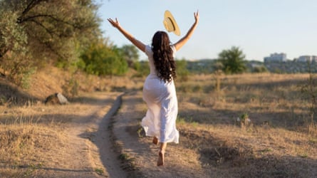 A woman in a white dress dancing in a field
