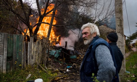 Local residents stand near a structure on fire after shelling in the town of Bakhmut, in eastern Ukraine’s Donbas region.