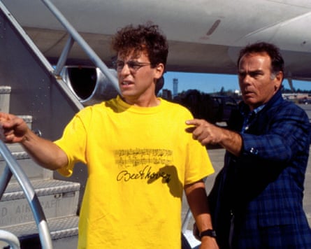 Man in yellow T-shirt by a plane.