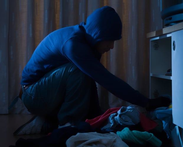 Burglar looking through cupboard
