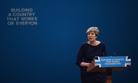Letters begin to fall off the backdrop as Theresa May delivers her keynote speech.