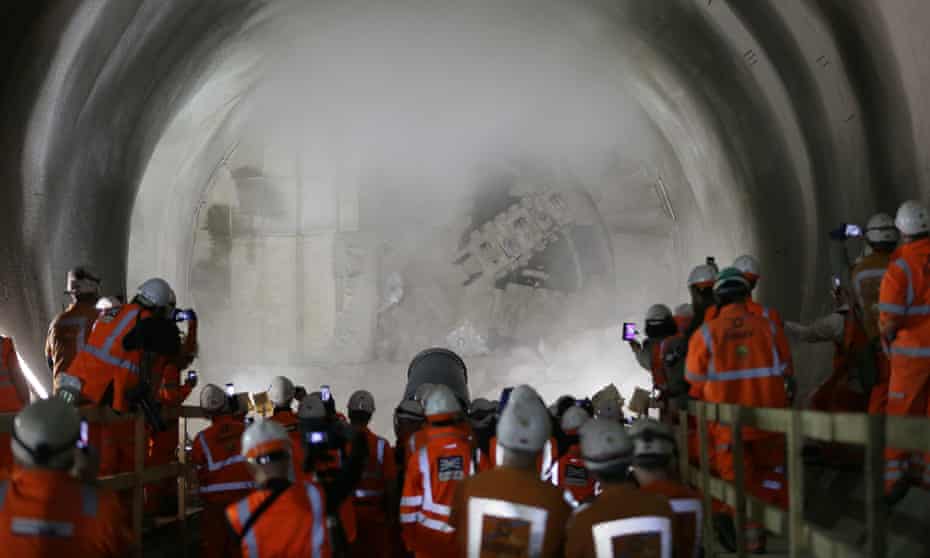 Workers watch and take pictures as tunnel boring machine Victoria breaks into the eastern end of the Liverpool Street Crossrail station in London in  March 2015. 