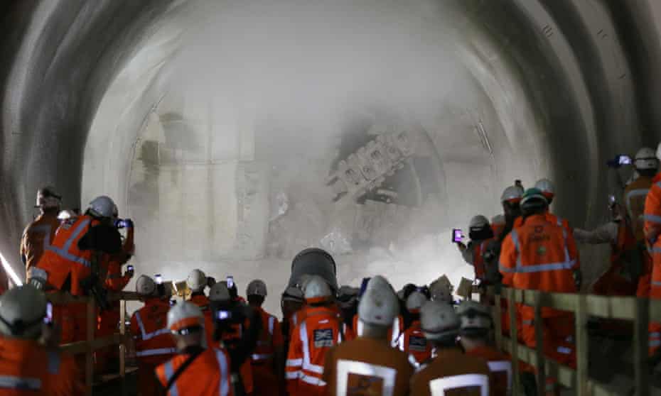 Workers watch and take pictures as a tunnel boring machine breaks into the eastern end of Liverpool Street Crossrail tunnel