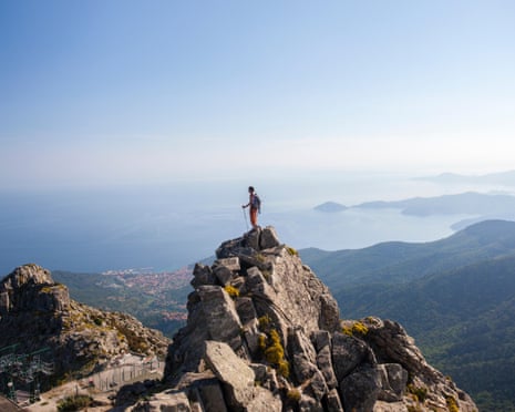 A hiker admires the sea from the top of Monte Capanne, Elba Island, Livorno Province, Tuscany