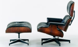 An Eames lounge chair and ottoman made from molded rosewood plywood with black leather upholstery and aluminium