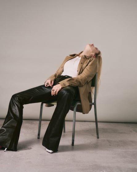 Portrait of Sam Taylor-Johnson leaning back in a chair. Vest and leather shirt, both toteme-studio.com; leather trousers, celine.com; boots, christianlouboutin.com.