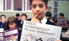 A pupil holds a card during a language teaching class in a secondary school classroom.