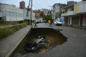 A car sits at the bottom of a sinkhole that opened up after heavy rains lashed the Pacific coastal resort of Acapulco, Mexico.