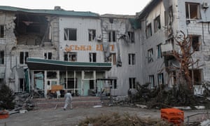 A man walks near the destroyed local hospital building in downtown Volnovakha, Ukraine, 26 March 2022.