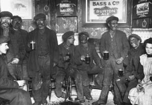 A group of coal miners, still dirty from the mines, discusses the impending national coal strike over pints of beer in February 1912.
