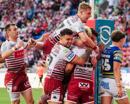 Taylor Kerr of Wigan celebrates with team-mates after scoring a try.