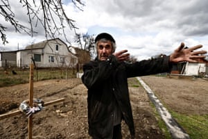 Kyiv region, Ukraine. Volodymyr Maksuta, 62, reacts while he recounts how his neighbour Yurii Ostapchuk, was killed by Russian troops, as he stands beside his grave