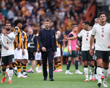 Manchester United coach Michael Carrick walks across the pitch looking downcast after a match