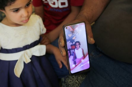Amar, the father of Algerian boxer Imane Khelif, sits with his children as he shows a picture of Imane when she was young, inside his house, in Tiaret province, Algeria.