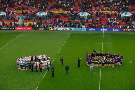 The England and Scotland squads form circles on the pitch after the final whistle of their Women’s Rugby World Cup 2025 quarter-final.